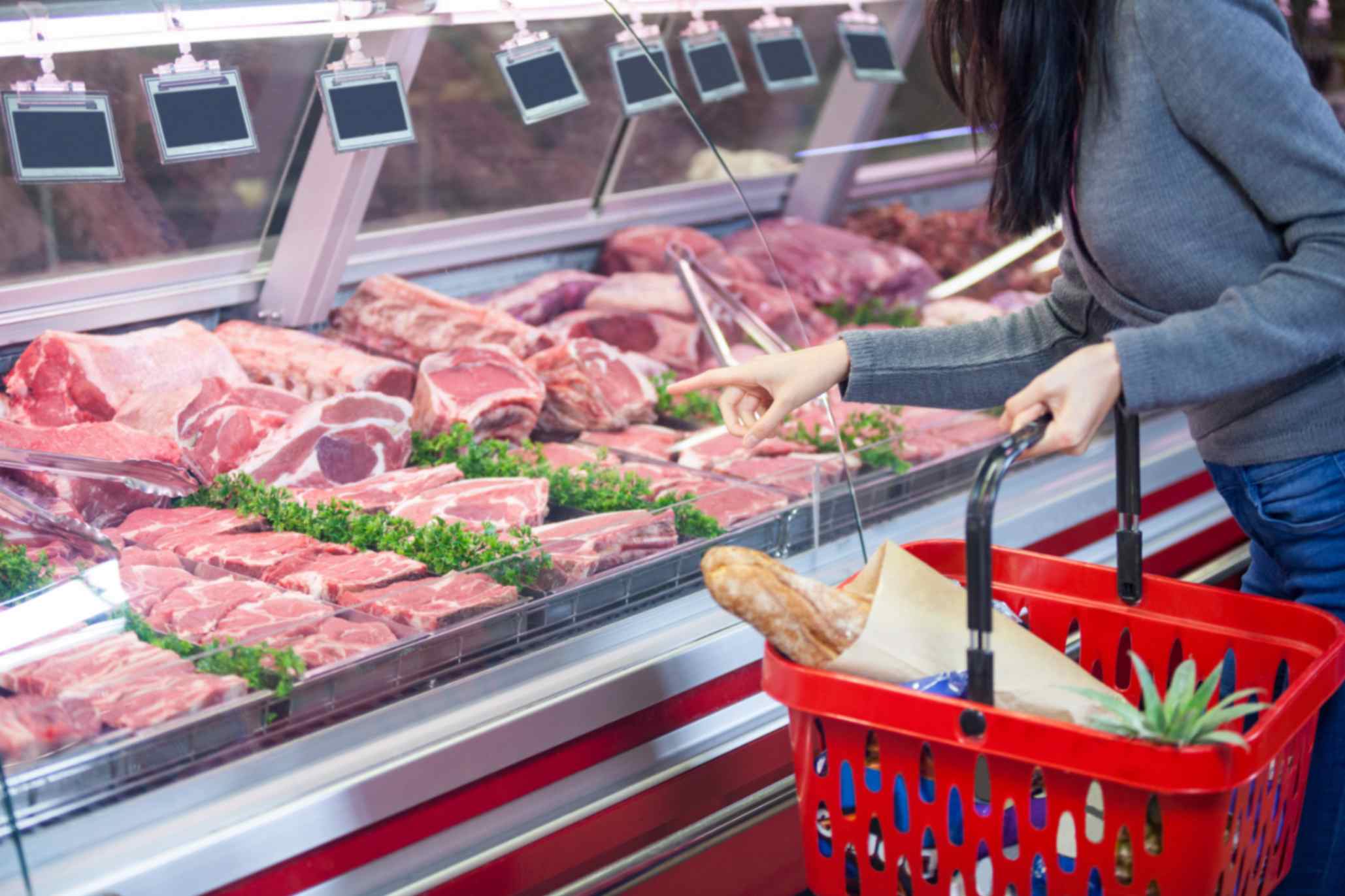 Budget halal cuts including chicken thighs, drumsticks, mince and lamb shoulder on a butcher's board