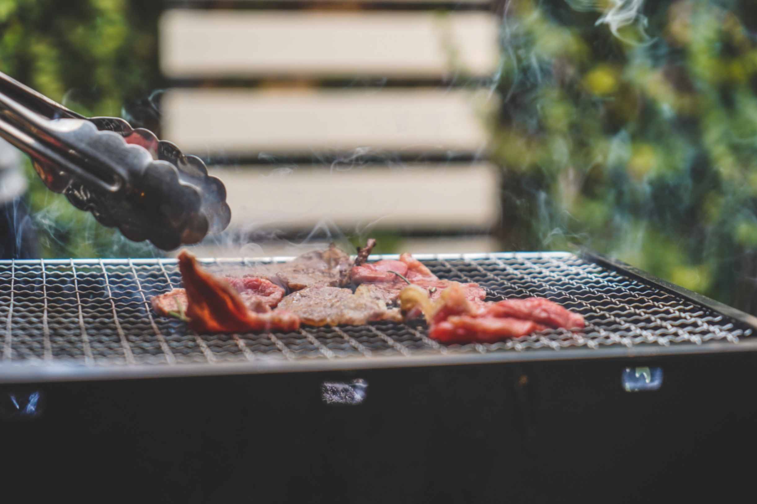 Halal chicken thighs, lamb chops and kebabs grilling over glowing charcoal coals